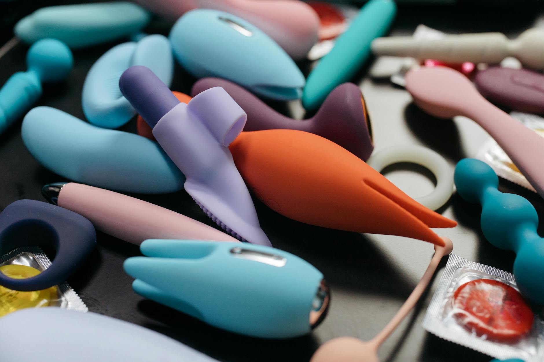 Colorful sex toys including lemon vibrators arranged on a bright yellow surface, showcasing modern clitoral massager design