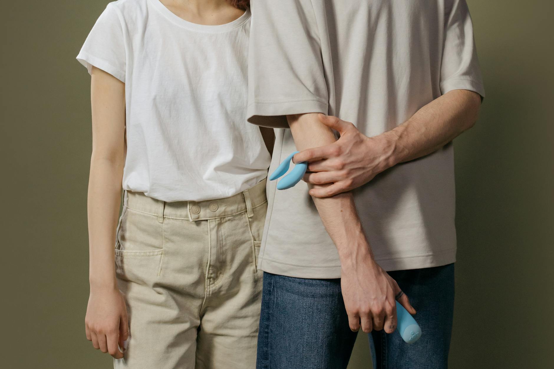 A couple standing close together, exploring shared intimacy with a modern vibrator during a video connection.