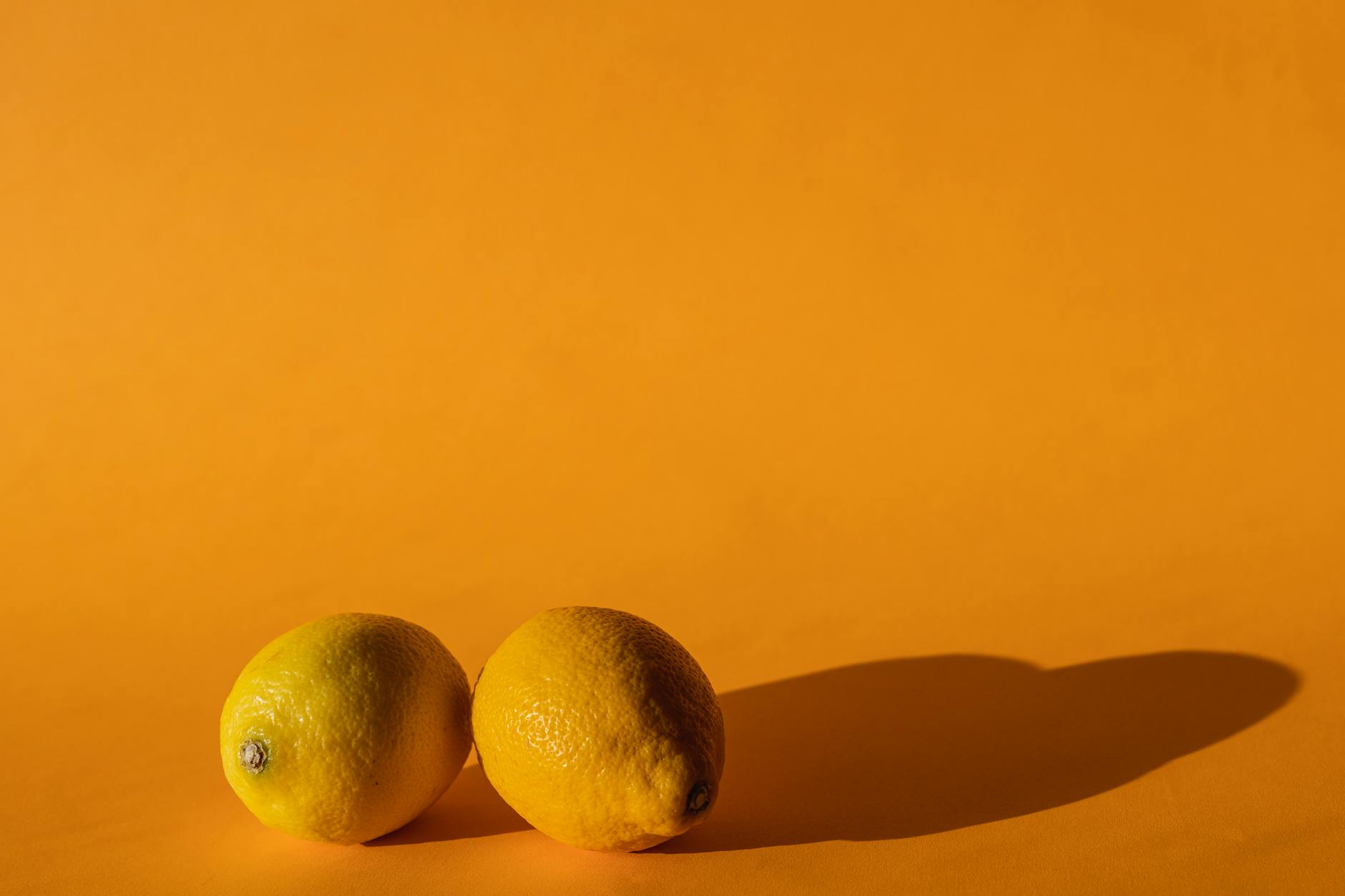 Ripe lemons on a bright yellow surface symbolising fresh approaches to reclaiming pleasure